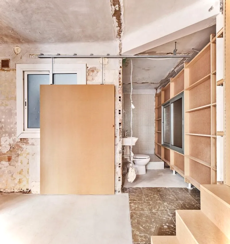 Escaleras y paredes revestidas de madera dentro de 10K House en Barcelona