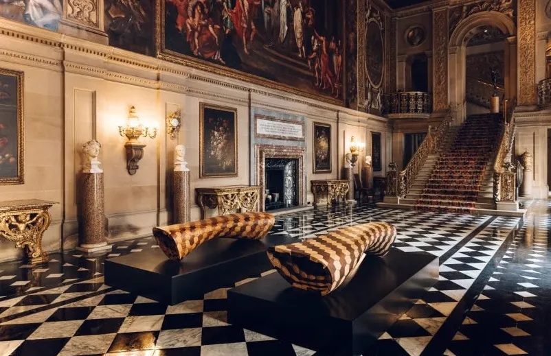 Interior de Chatsworth House con escaleras y bancos.