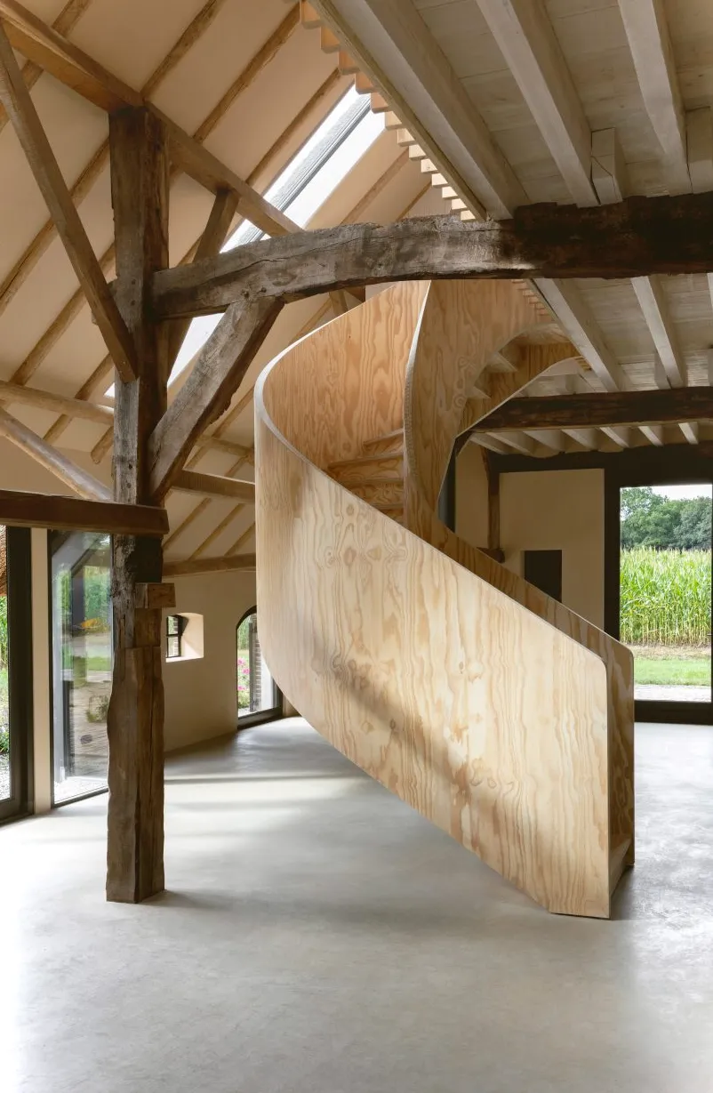Escalera de caracol de madera contrachapada en el granero del Ahof de Julia van Beuningen