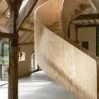 Escalera de caracol de madera contrachapada en el granero del Ahof de Julia van Beuningen