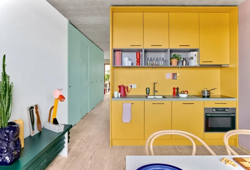 Cocina modular de color amarillo brillante en apartamento compacto