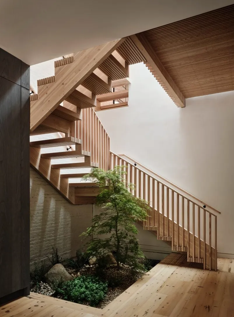 Una escalera de madera con un bancal en la base.