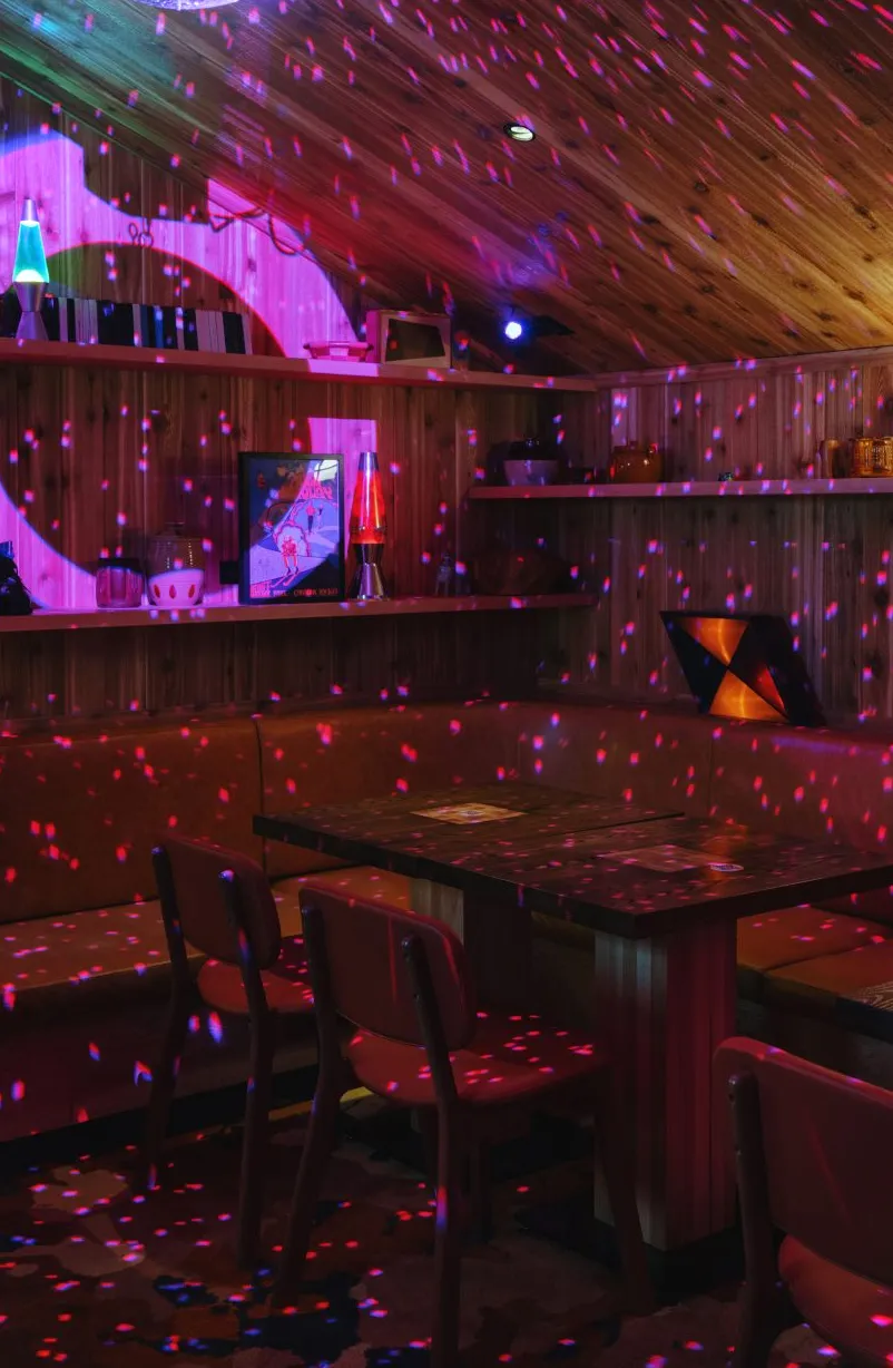 Sala de karaoke con bola de discoteca y lámparas de lava.