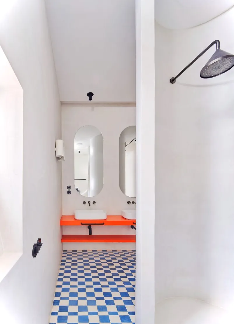 Cuarto de baño con encimera naranja y azulejos a cuadros.
