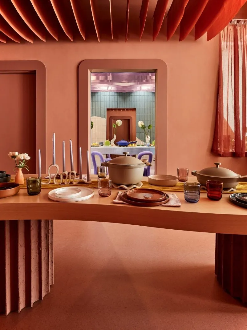 Un espacio enteramente color terracota con una mesa de comedor decorada con productos Our Place