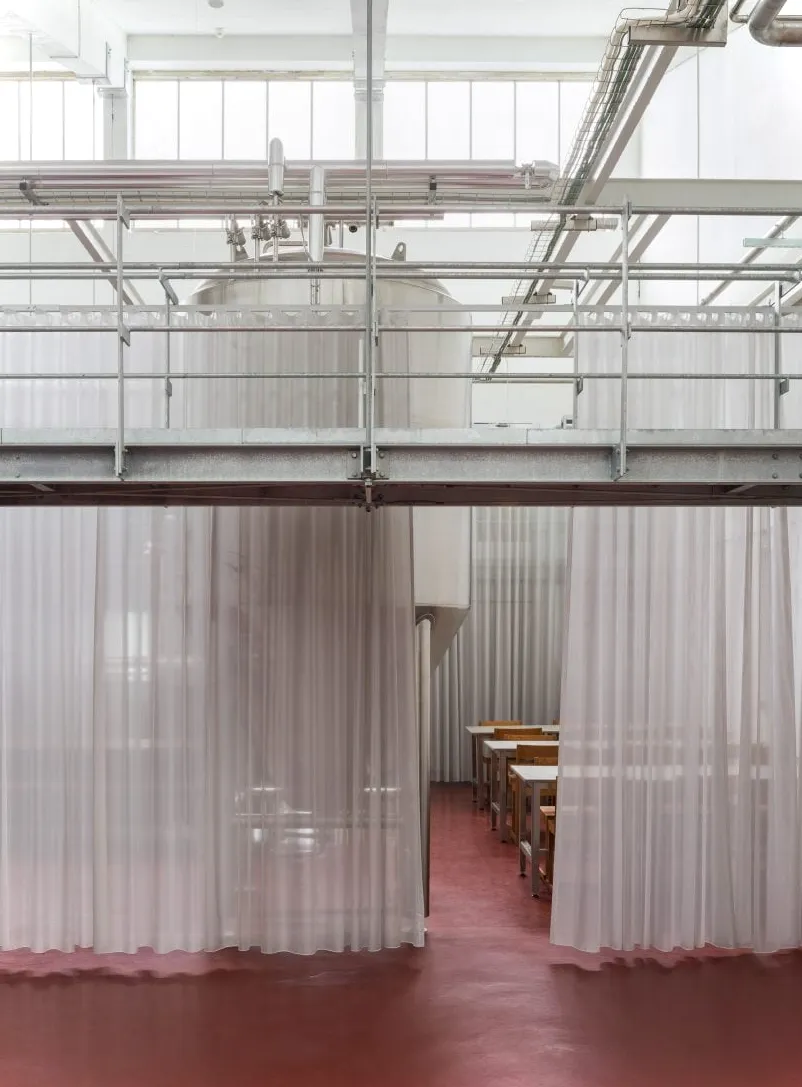 Cortinas semitransparentes dentro de una cervecer铆a dise帽adas por Pihlmann Architects