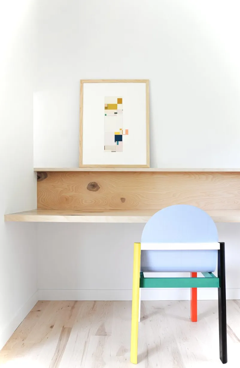 Rincón de oficina con escritorio de madera hecho a medida y silla colorida