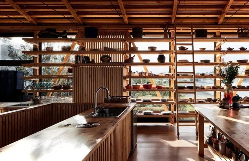 Una cocina con estanterías de madera.