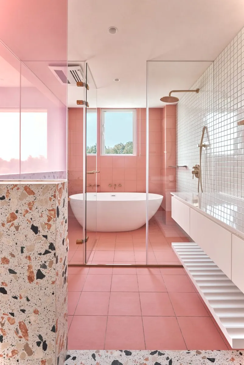 Un baño con azulejos rosas.