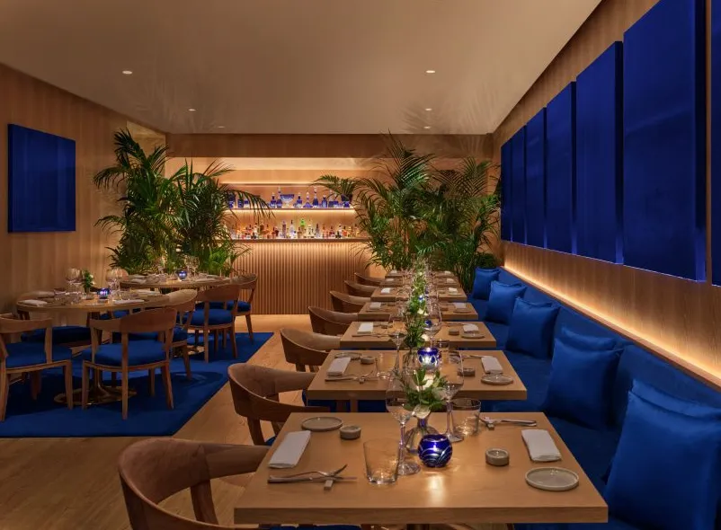 Restaurante con obras de arte y tapizados azules.